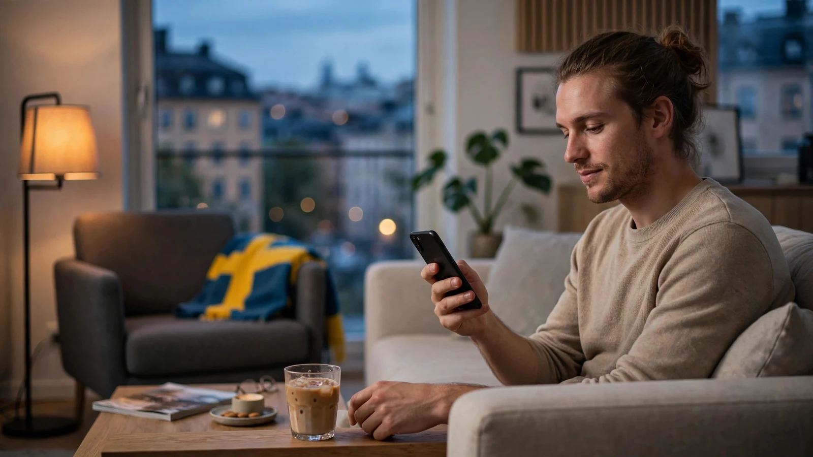 Svensk person i modernt vardagsrum med smartphone och kaffe